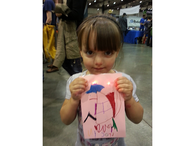 A young Fairegoer with her light-up card.